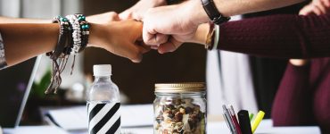 Group fistbump over work table.