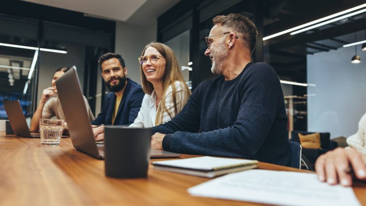 People in an office sitting at table to discuss talent acquisition