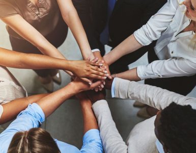 Group of people in a circle with hands together