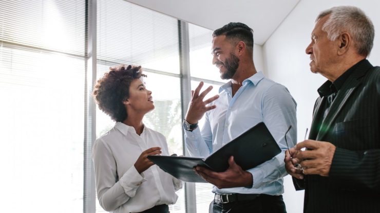 Three people in an office talking about Talent Attraction