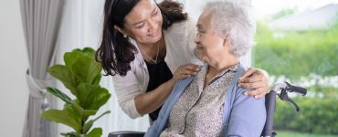 younger woman caregiving for a senior woman in a wheelchair